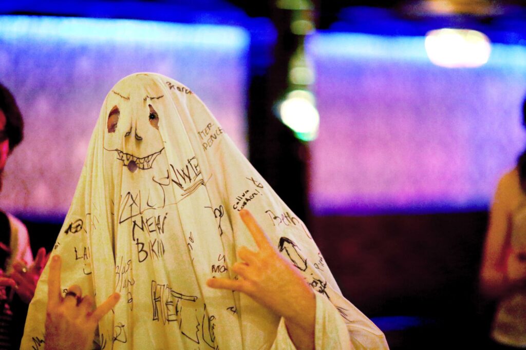 Photo of someone wearing a spooky ghost costume covered in signatures, pictures and messages while attending February 2025's Long Weekend Band Crawl in Waterloo, Ontario.