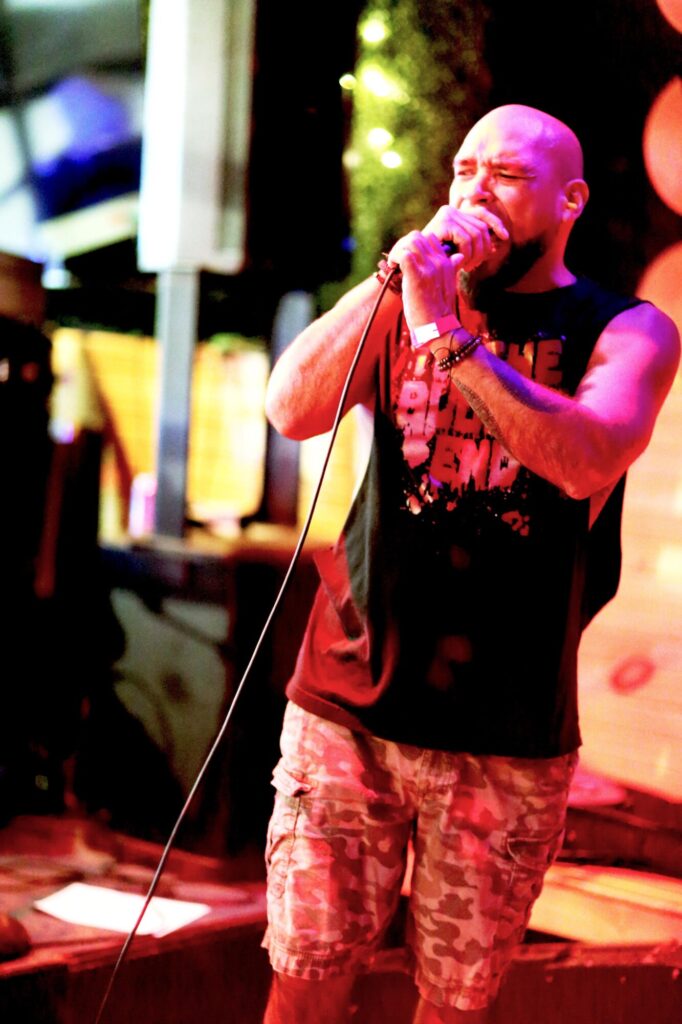 Photo of a performer bathed in purple light while singing during February 2025's Long Weekend Band Crawl in Waterloo, Ontario.