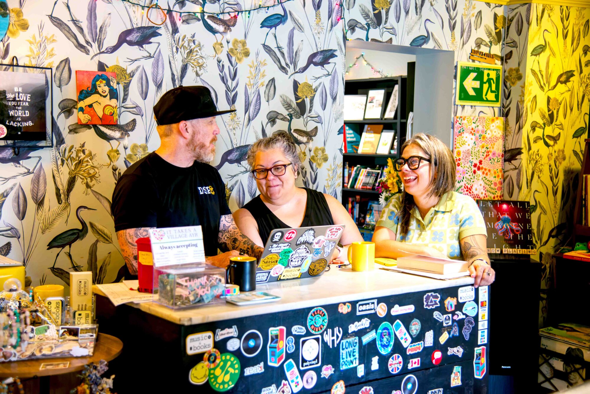 Photo of three people standing behind the till inside Music and Books, located in Ayr, Ontario.